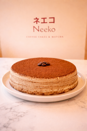 Tiramisu mille crêpes cake with coffee cream layers and cocoa dusting – Neeko